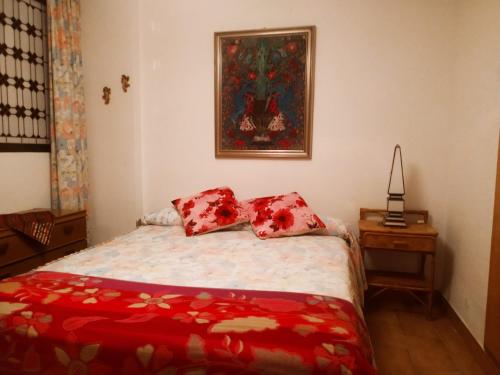 1 dormitorio con 1 cama y una pintura en la pared en apartamento Ana, en Granada
