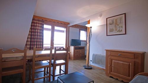 a living room with a dining room table and a desk at La Dame Blanche - Cimes et Neige in Puy-Saint-Vincent