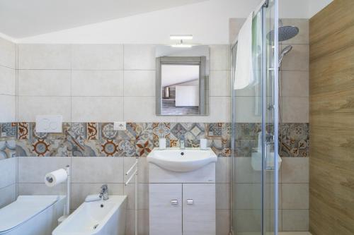 y baño con lavabo y espejo. en Appartamento Sud in Villa Sele, en Fontane Bianche