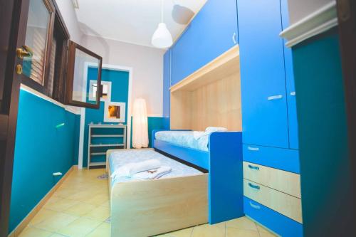 シラクーサにあるCasale Santuzza - Xenia Sicily Villasのベッドルーム(青いキャビネット、二段ベッド付)