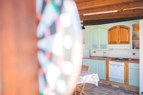 a kitchen with blue cabinets and a table in a room at Casale Santuzza - Xenia Sicily Villas in Siracusa