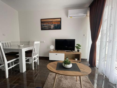 un soggiorno con tavolo e TV e una sala da pranzo di Apartmani Zivkovic Srebrno Jezero a Veliko Gradište