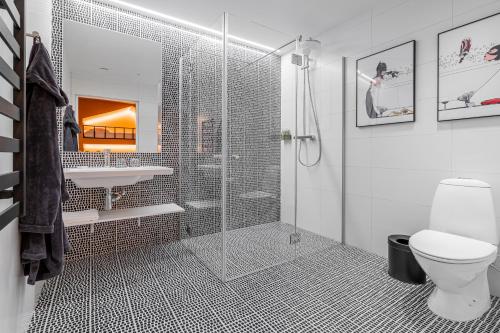 a bathroom with a shower and a toilet and a sink at ESE HOTEL in Birštonas