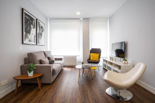 sala de estar con sofá y mesa en Apt nuevo! 2 hab, baño doble, garaje, Metro a 200m, en Madrid