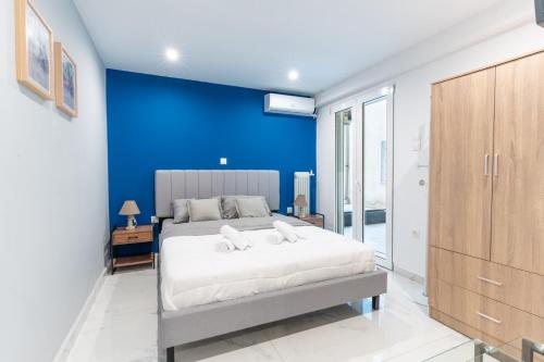 a bedroom with a large bed with a blue wall at Aiolos plateia apartment nea smyrni in Athens