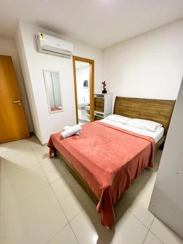 a bedroom with a large bed with a red blanket at Luz do Sol até 10 Pessoas com Ar Condicionado in Arraial do Cabo