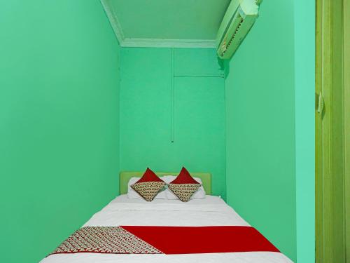 a bedroom with a bed with red and blue walls at OYO 92496 Faraas Homestay Syariah in Nongsa