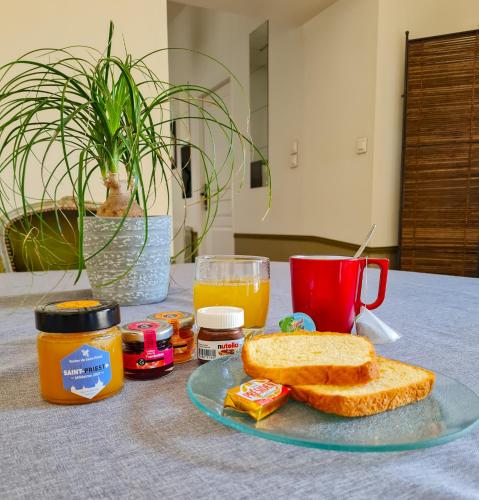 a table with a plate of toast and orange juice at Lyon Faubourg - Saint Priest in Saint-Priest