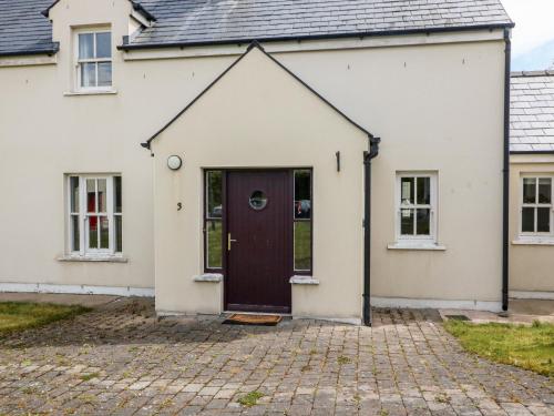 a white house with a brown door at No 3 an Seanachai in Dungarvan