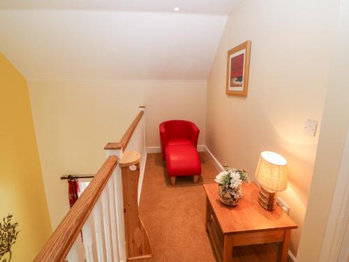 a stairway with a red chair and a table at No 3 an Seanachai in Dungarvan