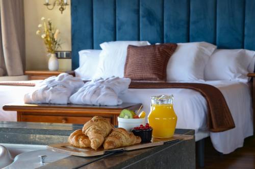 a tray of croissants and juice on a table in a bedroom at Hotel Roger de Flor by Seleqtta in Lloret de Mar