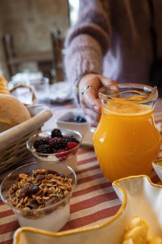 a table topped with bowls of fruit and orange juice at Villa Silene in Covilhã