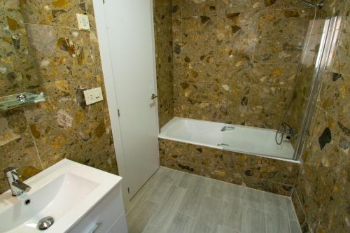 ein Badezimmer mit einer Badewanne und einem Waschbecken in der Unterkunft COVESA III Centro Levante Beach in Benidorm