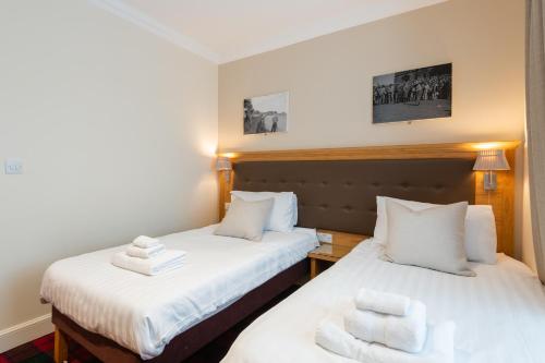 2 łóżka w pokoju z białymi ręcznikami w obiekcie 138 North Street - luxury 2 bed 2 bath with secret garden, summerhouse, putting green w mieście St Andrews