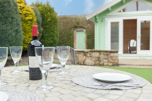 a bottle of wine sitting on a table with wine glasses at 138 North Street - luxury 2 bed 2 bath with secret garden, summerhouse, putting green in St. Andrews