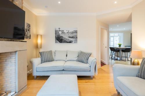 a living room with a couch and a fireplace at 138 North Street - luxury 2 bed 2 bath with secret garden, summerhouse, putting green in St. Andrews