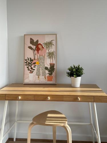 a wooden desk with potted plants and a picture at Queensview168 Apartments Moonee Ponds in Melbourne