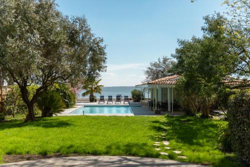a villa with a swimming pool and the ocean at Villa Les Délices in Cap-Ferret
