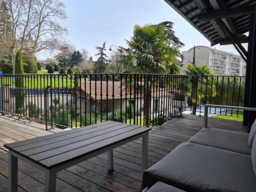 a wooden deck with a bench and a fence at Lyon Faubourg - Saint Priest in Saint-Priest