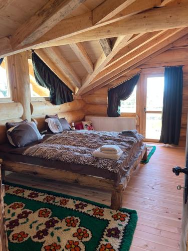um quarto com uma cama num quarto de madeira em ECO HOUSES ART OF LIVING - Еко къщи изкуството да живееш em Pamporovo