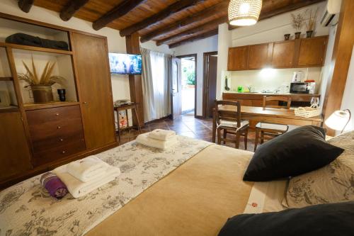 a bedroom with a large bed and a kitchen at Posada de Rosas in Mendoza