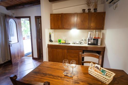 a kitchen with a wooden table with wine glasses on it at Posada de Rosas in Mendoza