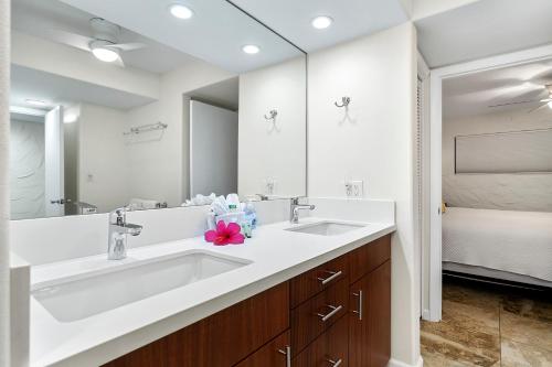 a bathroom with two sinks and a large mirror at Casa De Emdeko 104 in Kailua-Kona