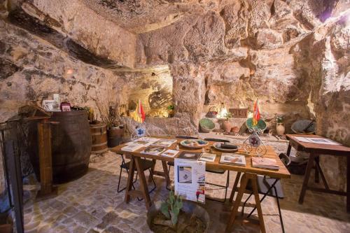 una habitación con una mesa con comida. en Case degli Avi 2, antico abitare in grotta, en Módica
