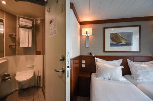 a bedroom with a bed and a bathroom with a toilet at Douro Cruiser in Vila Nova de Gaia