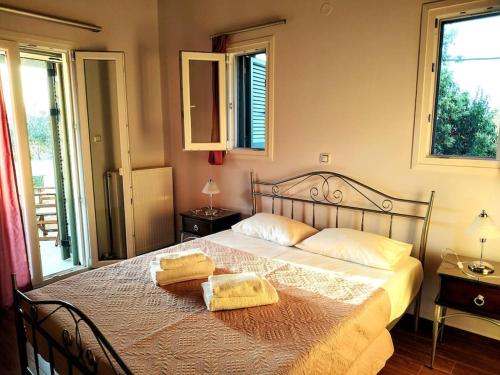 een slaapkamer met een bed met twee handdoeken erop bij Villa *Orizontas*/5' from town-sea/Mountain view in Lefkada