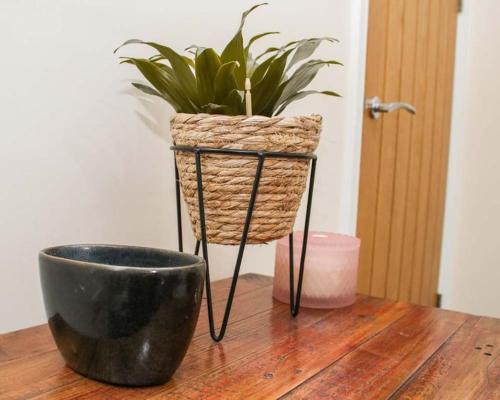 a plant in a basket sitting on top of a table at No25-Luxe Living Guest House- 2 Bed-WIFI-Free Parking-City- Beach in Swansea