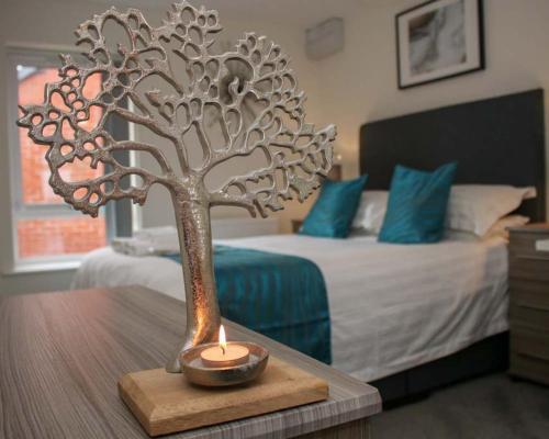 un centro de mesa de un árbol de metal en una mesa de madera en un dormitorio en No25-Luxe Living Guest House- 2 Bed-WIFI-Free Parking-City- Beach, en Swansea