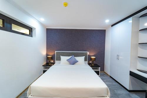 een slaapkamer met een groot bed en 2 nachtkastjes bij Nice-Duc Duong Apartment in Ha Long