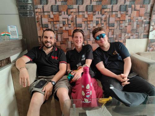 drie mannen op een bank met een glazen tafel bij Malhotra Guest House 50 Meter from Golden Temple in Amritsar