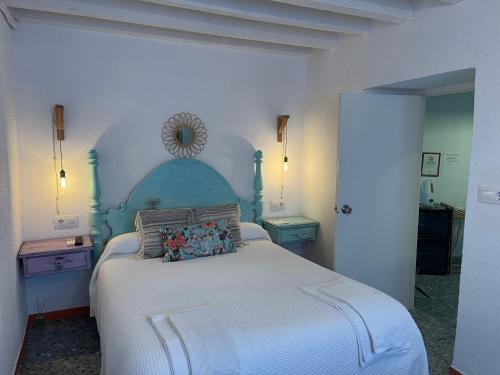 a bedroom with a large bed with a blue headboard at PENSION SOCAIRE CONIL in Conil de la Frontera