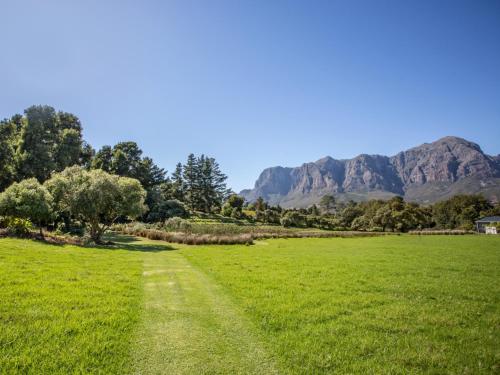 a path in a field with mountains in the background at Wechmarshof in Stellenbosch