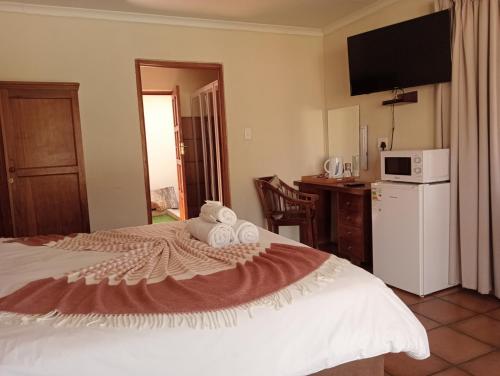 a bedroom with a bed with towels on it at Kuruman Hotel in Kuruman