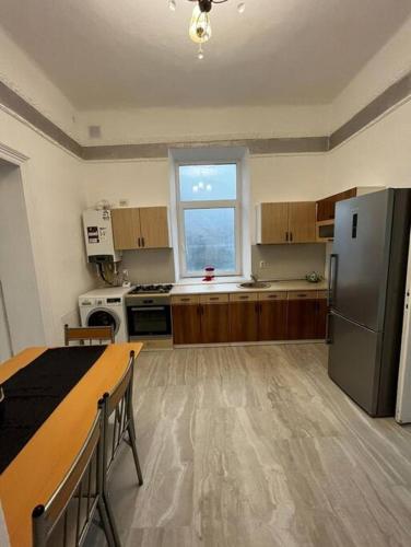 eine Küche mit einem Kühlschrank aus Edelstahl und einem Fenster in der Unterkunft casa buna 1 in Rădăuţi