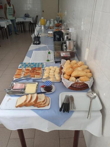 a table with a bunch of food on it at Hotel Brasil Pindamonhangaba in Pindamonhangaba