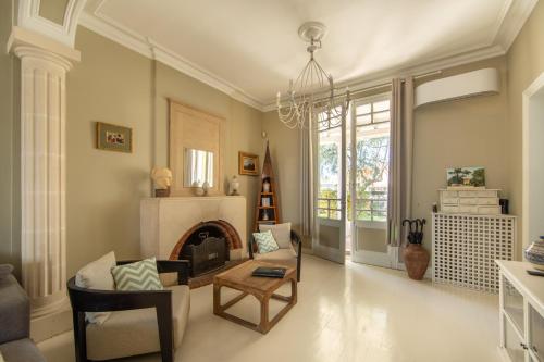 a living room with a fireplace and a chandelier at Villa Les Délices in Cap-Ferret