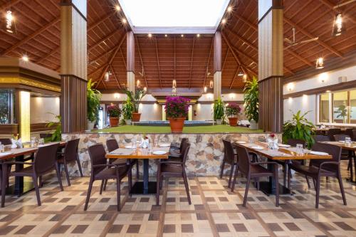 ein Restaurant mit Tischen und Stühlen in einem Gebäude in der Unterkunft Honeydewwz Exoticaa Hotel & Resort in Chikmagalur