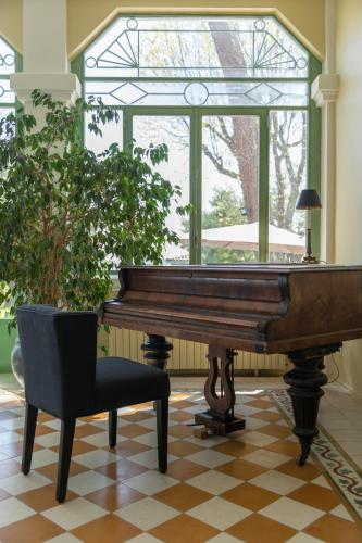 a piano and a chair in a room with a window at Villa Les Délices in Cap-Ferret
