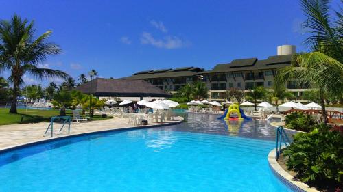 a swimming pool with a slide in a resort at Flat Beach Class Resort Muro Alto in Porto De Galinhas