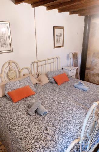 a bedroom with a bed with orange and gray pillows at CASA A ESCOLA in Piñeiro
