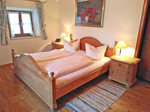 a bedroom with a large wooden bed with two night stands at Pension Brucker in Aschau im Chiemgau