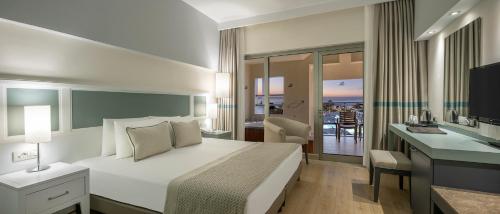 a bedroom with a bed and a desk with a television at Arcanus Hotels Sorgun - Ultra All Inclusive in Side