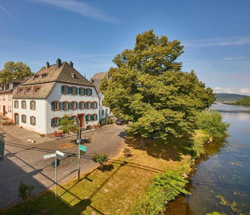 a large white building next to a river at NEU!!! Moselbleibe Uferallee in Bernkastel-Kues