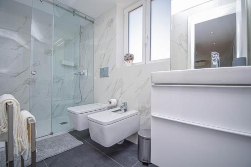 uma casa de banho com um lavatório, um WC e um chuveiro em Central & Stylish 2 Bedroom Apartment w/ Balcony em Cascais