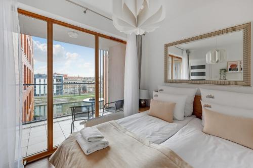 a bedroom with a large bed and a large window at Downtown Apartments Aura - Riverside & Parking in Gdańsk