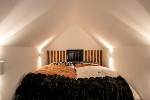 a large bed in a room with a pointed ceiling at House Raduha in Luče